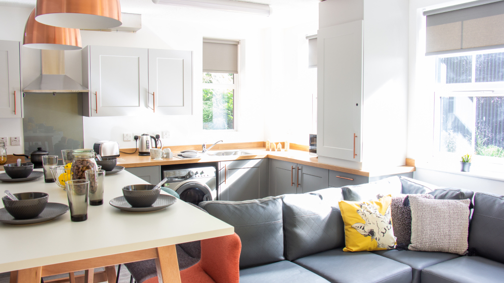 A modern kitchen, with a sofa and high dining table